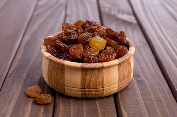 Dark raisins in a wooden dish