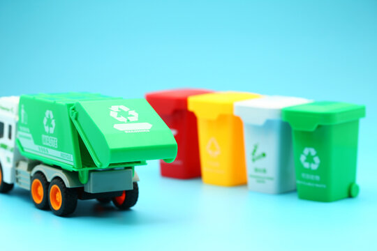 Garbage removal truck and garbage sorting bins on blue background