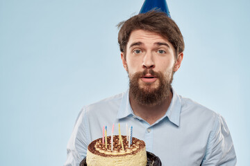 A lonely man in a shirt with a cake in his hand is celebrating his birthday