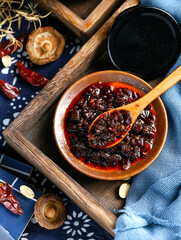 A wooden spoon to scoop up a spoonful of Sichuan chili sauce - obrazy, fototapety, plakaty