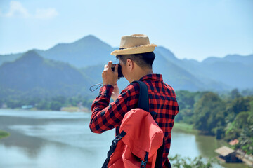 Young man photographing with vintage camera