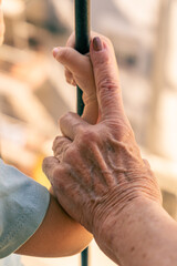 Old woman's hand taking the arm of a child. Concept of care and age difference.