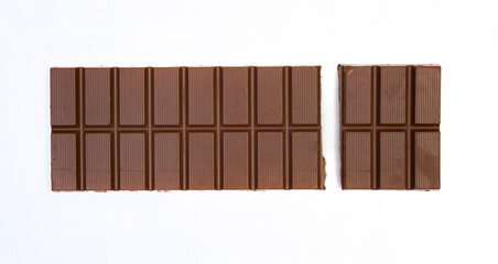 sweet and delicious whole chocolate bar is lying on white background, photo taken from above
