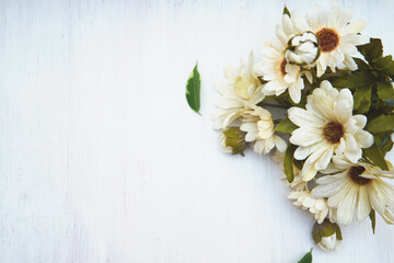 White flower petals on wooden background copy space, bouquet of artificial flowers