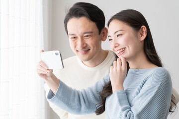 携帯を見る日本人カップル