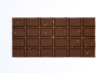 sweet and delicious whole chocolate bar is lying on white background, photo taken from above