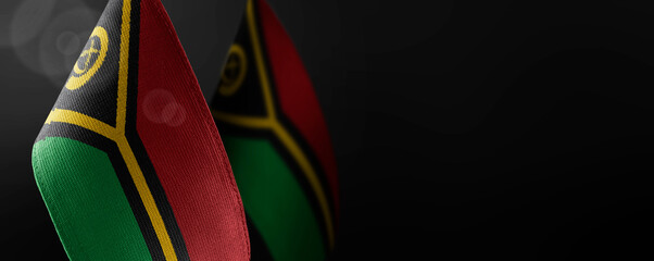 Small national flags of the Vanuatu on a dark background