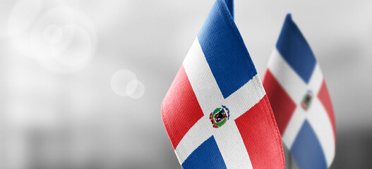 Small national flags of the Dominicana on a light blurry background