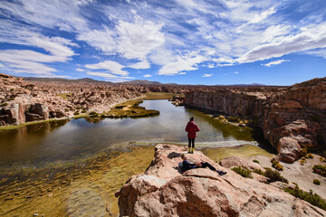 Fototapeta na wymiar Tourist enjoying the beautiful view of the hidden Laguna Negra Valley in the Salar de Uyuni, Bolivia