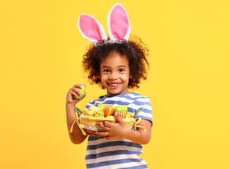 Cheerful ethnic kid holding Easter present in hands and laughing