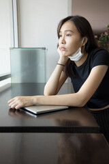 Obraz premium Woman improperly wearing face mask, concept of wearing face mask in wrong way, not covering nose and mouth, ignoring precaution measure or new normal social distancing lifestyle