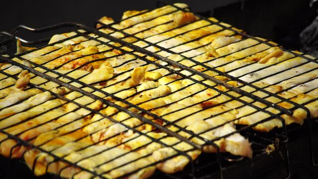close-up of flattened out barbecued golden crispy skin chicken tabaka on grid, side view from above