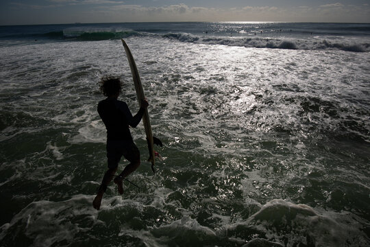 A Surfer Jumps Off The Pier On Durban Beach Front.