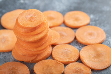 Stack of carrot slices on grey background