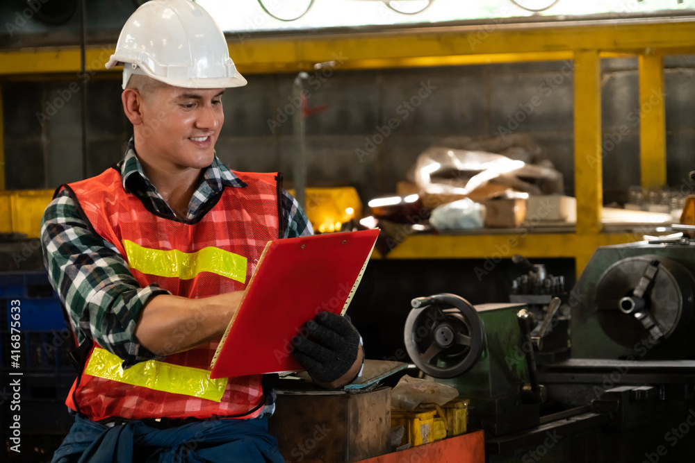 Poster manufacturing worker working with clipboard to do job procedure checklist . factory production line 