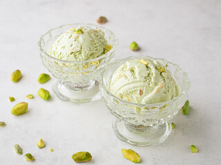 Pistachio ice cream in glass bowls and nuts