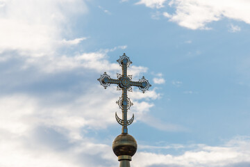 Fototapeta na wymiar A golden cross on the dome of an Orthodox Christian church