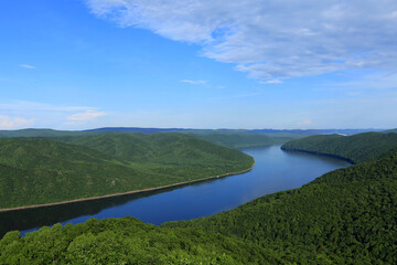 Aerial natural view of water and hills, green forest; meandering river