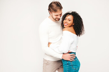 Smiling beautiful woman and her handsome boyfriend. Happy cheerful multiracial family having tender moments on grey background  in studio. Multiethnic models hugging. Embracing each other.Love concept