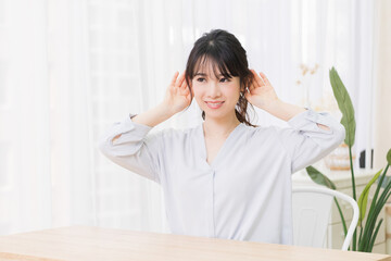 部屋で聞き耳を立てる若い女性