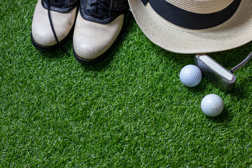 Golf ball and golf shoes are on green grass background
