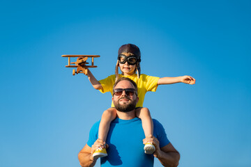 Father and son playing against blue summer sky background