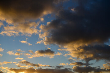 Naklejka na ściany i meble Arrière-plan de texture de ciel au coucher du soleil, aux nuages colorés jaune et sombre sur fond de ciel bleu