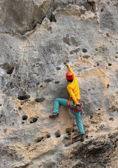 Woman rock climber climbing on the cliff