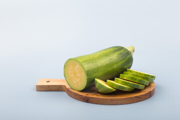 Courgette or Zucchini on wooden cutting board.