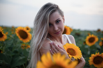 Beautiful woman dresssed boho style clothes walking on sunflowers field