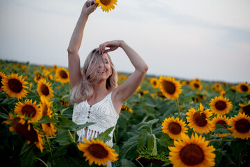 Beautiful woman dresssed boho style clothes walking on sunflowers field