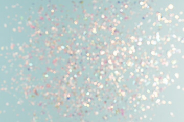 pearl confetti sparkles on blue holiday background. Festive backdrop or greeting card for designers.