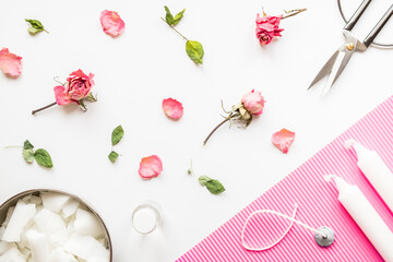 DIY concept. Wax, wick, dry roses - ingredients for making handmade candles on a light background. Flat lay. View from above.