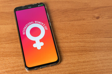 Phone with International Women’s Day logo on table