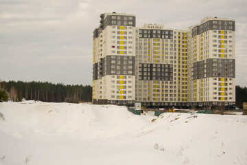 the foundation pit for the construction of a new house is covered with snow. new residential building near the forest. separate house. frozen construction