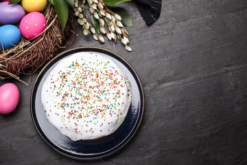 Flat lay composition with traditional Easter cake on black table. Space for text