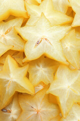 Pile of delicious carambola slices as background, top view