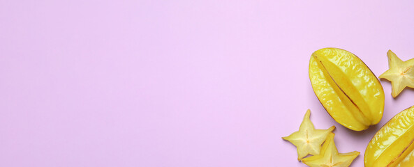 Delicious carambola fruits on violet background, flat lay. Space for text