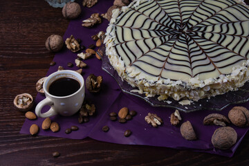 Delicious esterhazy cake with nuts, almonds, black and white chocolate and a cup of coffee on a dark background top view copy space, close up