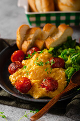 Scrambled eggs with salad and grilled tomatoes