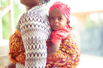 selective focus of beautiful african baby  at her mother's back