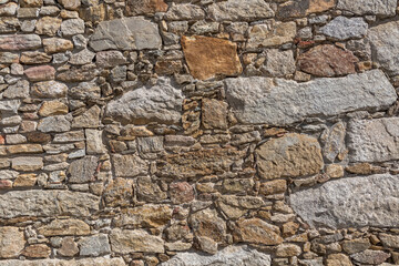 Detail view of a stone texture in detail of rustic granite wall, typically used on portuguese architecture