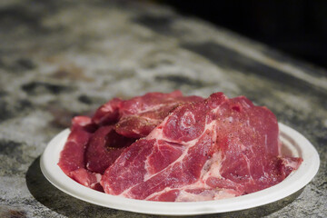 Pork on the plate waiting to be grilled.