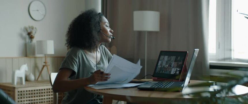 MED Black African American female working from home, having a video conference call with colleagues. WFH, stay home, COVID-19 coronavirus pandemic new normal concept