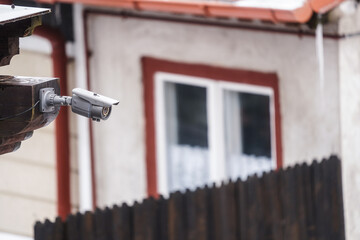 Surveillance camera mounted on the corner of a house.