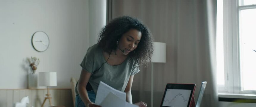 MED Black African American female working from home, having a phone call with client or office. WFH, stay home, COVID-19 coronavirus pandemic new normal concept