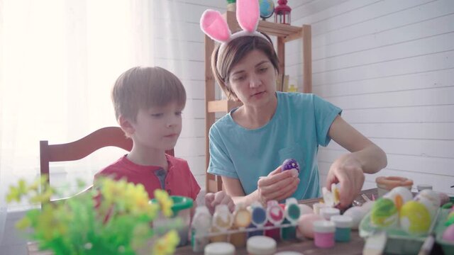 Happy easter. Family mother with son painting eggs for easter