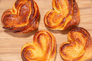 Delicious sugar buns in a wicker basket with paper and on a wooden board. Homemade baking