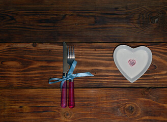 cutlery plate heart shaped on wooden background