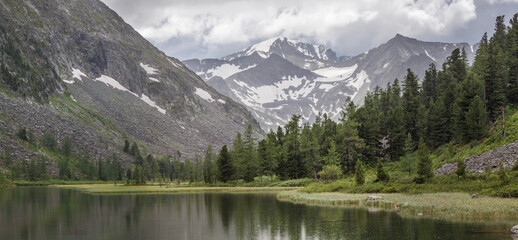 Fototapeta premium Wild lake in the mountains of Siberia. Cloudy weather, it's raining.